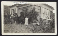 Izora Powell standing in front of her home