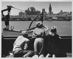 Children gazing at the San Francisco Ferry Building from the deck of a ferry, San Francisco, California, about 1955