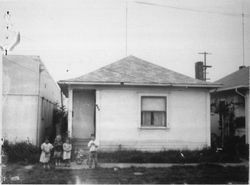 Four unidentified children standing in front of a house at 304 Second Street, Petaluma, California, about 1950