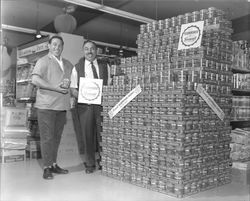 Two unidentified grocers advertising Van Camps pork and beans at Sissa's Market on Southwest Boulevard, Rohnert Park, California, 1967