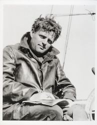 Jack London reading a book at helm of Roamer