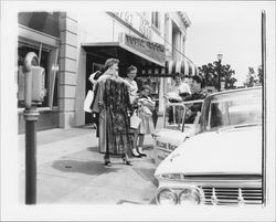 Cecilia Payne, her models and a young girl outside the Topaz Room's entrance on Hinton Avenue as they prepare for the "Dramatic Moods" fashion show in the Topaz Room, Santa Rosa, California, 1959