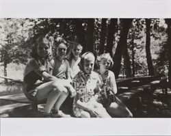 Mary McGregor and four unidentified people sitting on a picnic table, about 1938