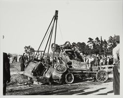 Tow truck separating a pile of wrecked racing cars