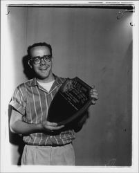 Sidney McCausland holding I.O.O.F. trophy as winner of United Nations pilgrimage at Petaluma High School, Petaluma, California, 1957