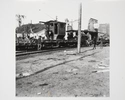 Steam engine pulling railroad cars up Main Street