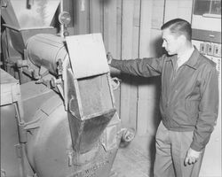 Assistant Manager Dolph Hill, Junior at the Golden Eagle Milling Company pellet machine, Petaluma, California, 1955