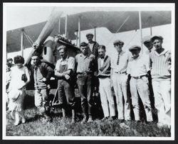 Group of people posing by an airplane