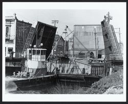 Tehama tug boat pushing a barge underneath the Washington Street drawbridge
