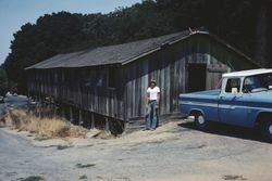 Geoffrey Skinner standing in front of chicken house at the corner of Jewell and Leland Avenues in Sebastopol, Calif., Aug. 1978