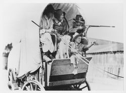 Family in a covered wagon at the centennial of the founding of Sonoma Mission