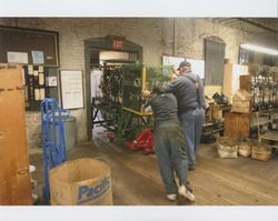 Big Dennis Henderson and Juan Rodriguez pushing a braiding machine on a pallet jack, Sunset Line & Twine Company in Petaluma, California, Dec. 2006