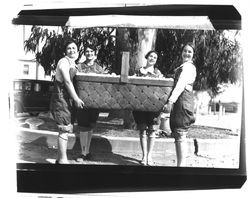 Four women with large basket of eggs, Petaluma, California, about 1930