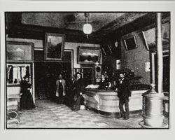 People standing by a hotel desk in the lobby of an unidentified hotel