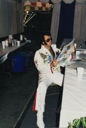 Flying Elvi reads a newspaper at the Sonoma County Fair, Santa Rosa, California, 1997