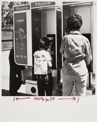 Young boy and woman use public phones at the Sonoma County Fair, Santa Rosa, California