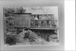 Three men at a logging camp