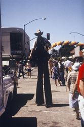 Man on stilts greets crowds celebrating the California Cooperative Creamery's 80th anniversary celebration in downtown Petaluma, California, July 17, 1991