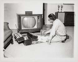 Bruner television technician repairing a TV in a home, Santa Rosa, California, 1964