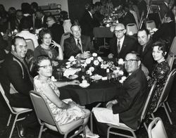 Jack W. Dei and Mary Dei and others seated around a dinner table while attending the League of California Milk Producers Convention, November 1971