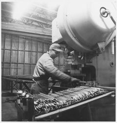 Worker bending metal parts at an unidentified machine shop, 1950s or 1960s