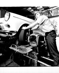 Changing a tire at Downey Tire Center, Santa Rosa, California, 1971