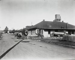 Trucks with milk cans parked on the Baker Street side of the Petaluma Cooperative Creamery, about 1925