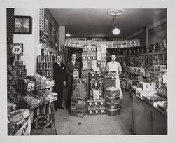 Men posing beside a detergent display in an unidentified grocery store