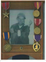 Photo of framed black and white photograph of Edward G. Rainford with his military medals exhibited around the frame