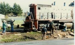 Workmen are removing the P&SR railroad tracks on South Gravenstein Highway 116 near Industrial Avenue and Sparkes Road, about 1984 with the help of a Southern Pacific engine