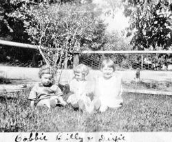 Bobbie Lambert, Billy Lambert and Dixie (?) seated in the grass