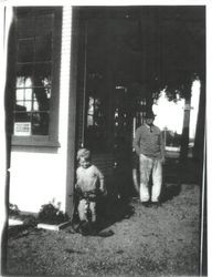 Dr. Lynch in background and child Wallace Walton on tricycle by Walton Service Station in Sebastopol in late 1920s or early 1930s