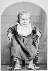 Unidentified young girl seated in a highchair, 1860s