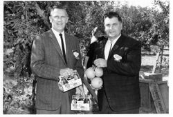 Don Hallberg, of O. A. Hallberg & Sons apple products and Paul LeBaron of Clyde LeBaron Co. Both holding Hallberg apples and apple juice, 1960s