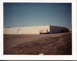 Juice plant and warehouse with view of trailer that had old design label from O. A. Hallberg & Sons Apple Products cannery in Graton, California, 1960s