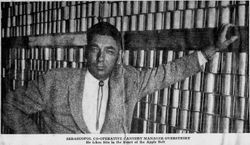 Sebastopol Co-op Cannery Manager William (Bill) Overstreet stands beside unlabeled tin cans at the cannery