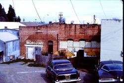 Back of stores on west Main Street and Mode O'Day store sign from Edman Way, Sebastopol, California, 1977