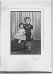 Studio portrait of an unidentified young girl and a toddler, about 1940s