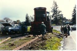 Workmen are removing the P&SR railroad tracks on South Gravenstein Highway 116 near Industrial Avenue and Sparkes Road, about 1984 with the help of a Southern Pacific engine