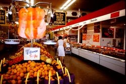Interior of an unidentified supermarket store in Sebastopol, California, with advertisements for Blue Chip Stamps and Sunkist oranges, 1970