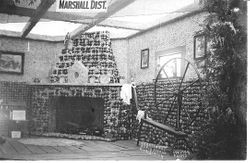 1914 Gravenstein Apple Show display by the Marshall District of an interior of a home with a fireplace and walls made of whole and sliced dried apples