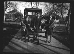 Three unidentified children, about 1930s in front of a car