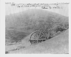 Bert Titus sitting on the water wheel of the Old Mill on lower Willow Creek near Coleman Valley