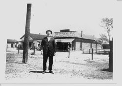 Unidentified man standing in front of Brunswick Tire and Tubes and Valentine Auto Machine & Light Co. building in Sebastopol