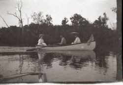 Three people (one man and two women) in small boat on Lake Jonive