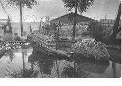 1912 Gravenstein Apple Show display of the sinking Titanic and an iceberg made of whole and dried sliced apples in a square pool of water