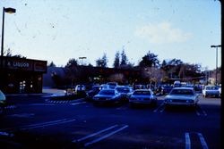 Parking lot of the Safeway store, center background, and Ernie's Liquor store on North Main Street Sebastopol, California, 1970s