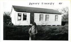 Danny Tinny in front of a wood frame home located at 4586 Gravenstein Highway North, Sebastopol, California, 1944