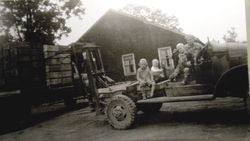 Twin Hill Ranch owner Darrel Hurst and family members sit atop the area's first apple box forklift loader in 1950