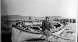 Sailor Jerry Ames sits on a rowboat at Bodega Bay, about 1918